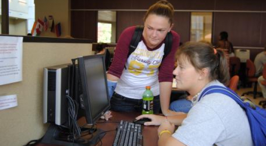 Students sitting at a computer.